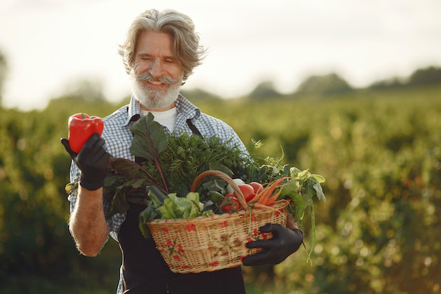 A man holding a basket of vegetables in his hands.